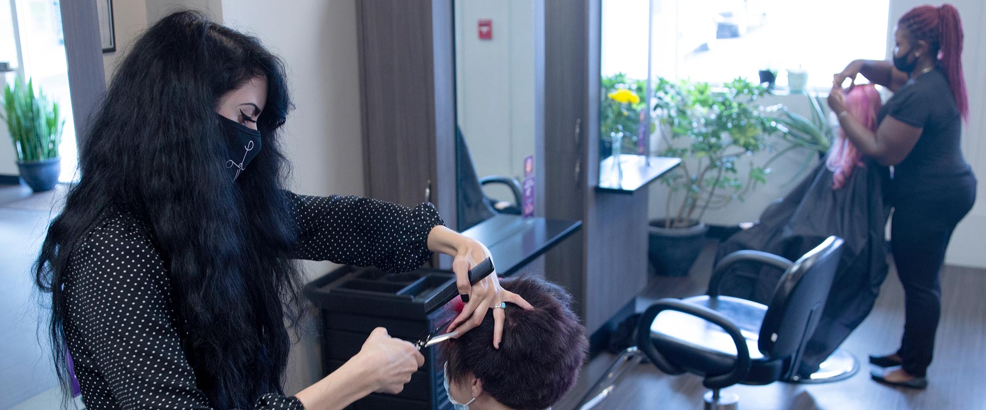 Woman giving another woman a haircut